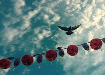 Low angle view of lanterns hanging against sky