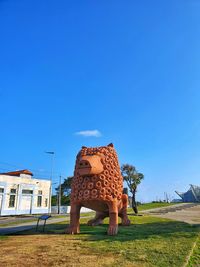 View of an animal on field against clear blue sky