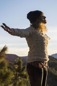 Rear view of woman standing against sky