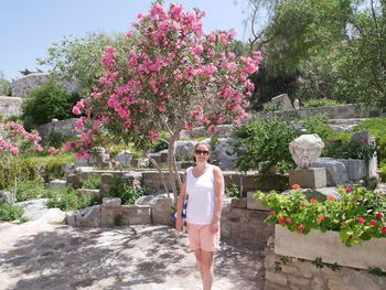 Portrait of woman standing against plants in garden