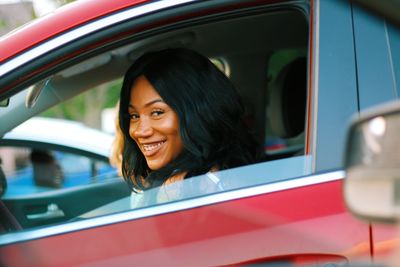 Portrait of smiling woman sitting in car