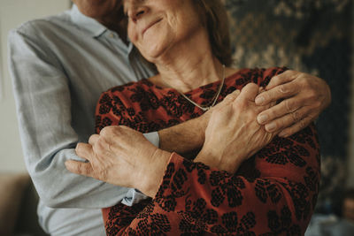 Senior couple hugging at home