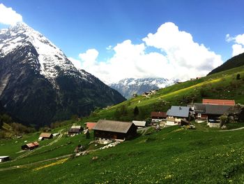 Panoramic view of field and houses against sky