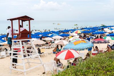 People at beach against sky