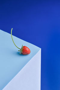 Close-up of strawberries on table against blue background
