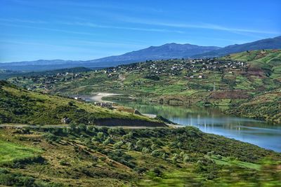 Scenic view of lake by mountains against sky