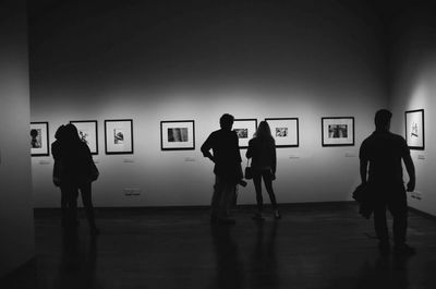 Rear view of silhouette people standing against wall