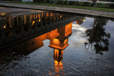 Reflection of illuminated building in puddle at lake