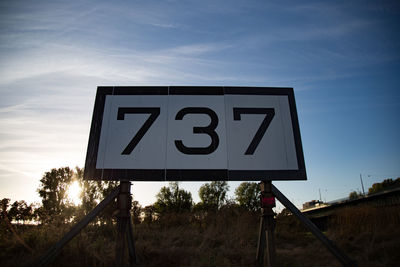 Low angle view of road sign against sky