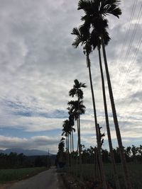 Road passing through landscape against cloudy sky