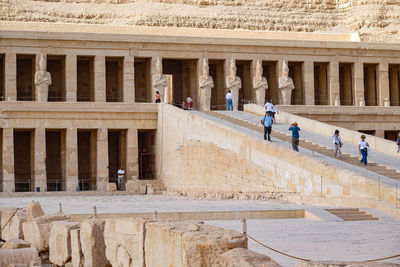 Egyptian palace. columns. entranceway with people climbing stairs.