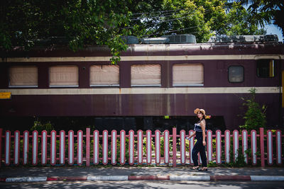 Rear view of woman standing by building in city