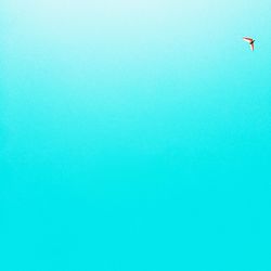 Low angle view of airplane flying against clear blue sky