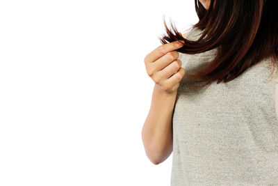 Close-up of woman holding hands over white background