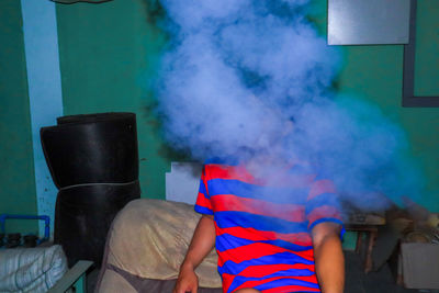 Young man smoking while sitting at home