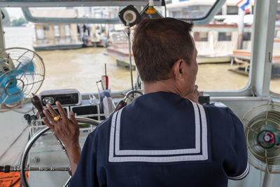 Rear view of man standing in bus