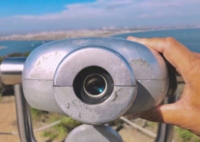 Close-up of person holding coin operated binoculars