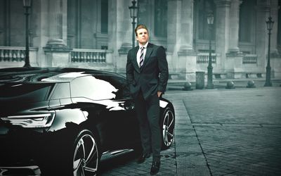 Confident businessman standing by car on road