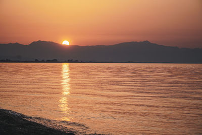 Scenic view of lake against romantic sky at sunset