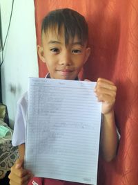 Portrait of boy holding paper