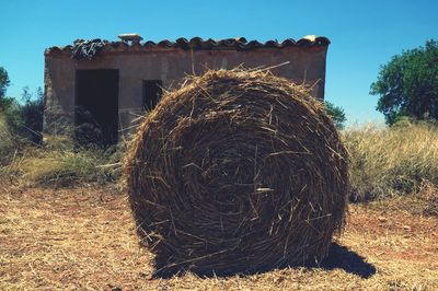 Hay bales on field against clear sky