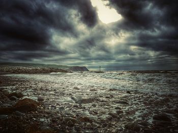 Scenic view of sea against storm clouds