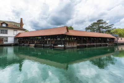 Houses by lake against sky