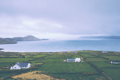 Scenic view of field and sea against sky