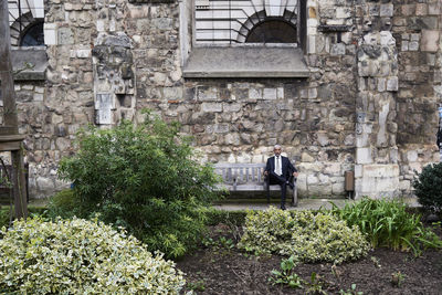 Uk, london, senior businessman sitting on bench in a courtyard relaxing