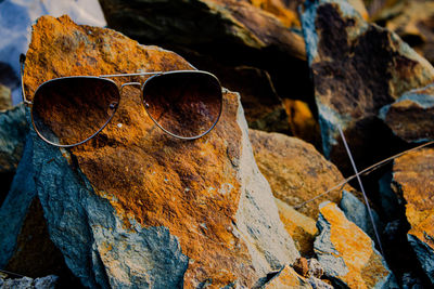 Close-up of sunglasses on rock
