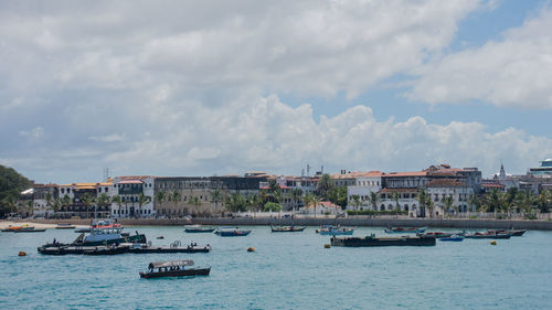 Boats in sea against buildings in city