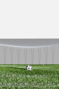 Soccer ball on field against clear sky