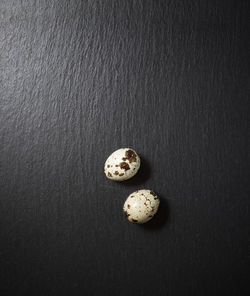 Quail eggs on a black table.