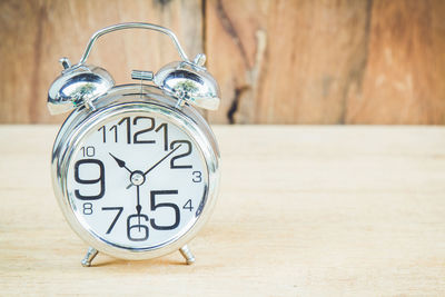 Close-up of alarm clock on wooden table