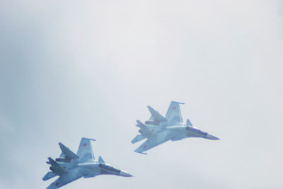 Airplane flying against sky over white background