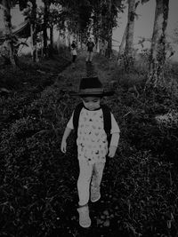 Full length portrait of girl standing by tree