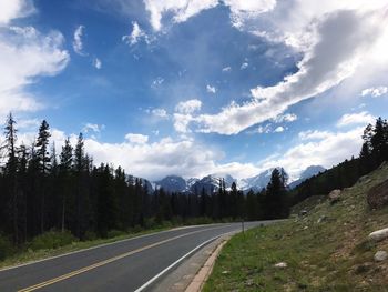 Road by trees against sky