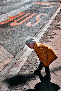 The boy is waiting for the bus at the bus stop.