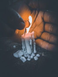 Close-up of hand holding burning candle