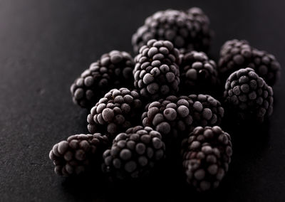 Close-up of berries on table against black background