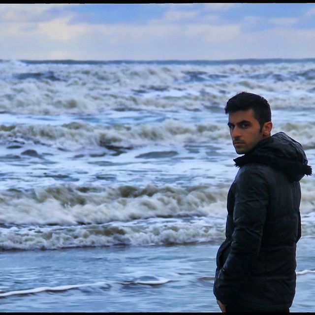 sea, water, lifestyles, leisure activity, beach, horizon over water, sky, young adult, person, standing, waist up, casual clothing, nature, shore, scenics, beauty in nature, three quarter length, tranquility