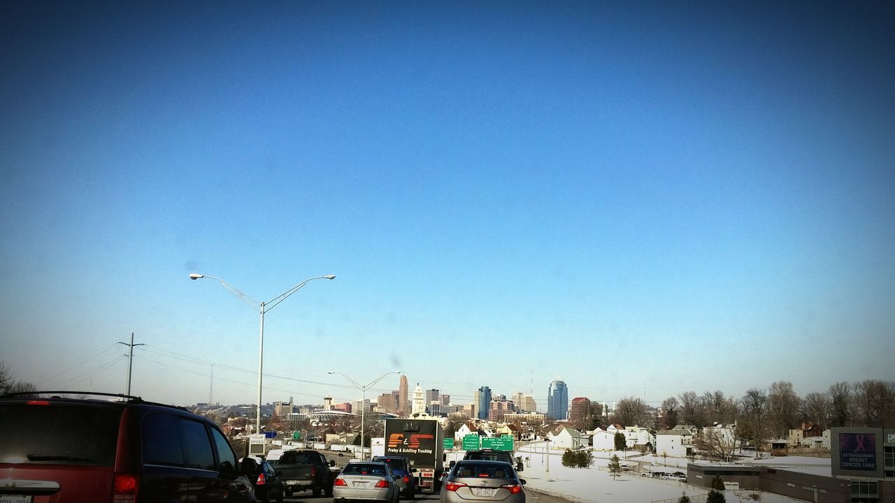 transportation, car, mode of transport, land vehicle, clear sky, building exterior, built structure, architecture, city, copy space, road, street, traffic, blue, street light, vehicle, on the move, city life, stationary, day