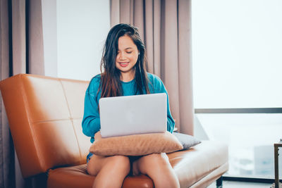 Woman sitting on sofa at home