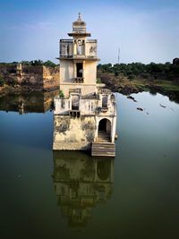 Reflection of building in lake against sky