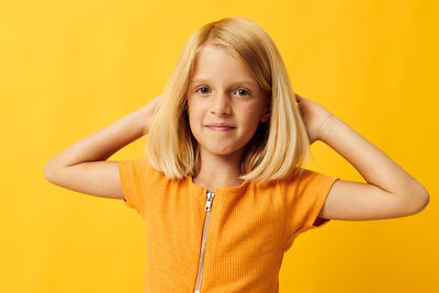 Portrait of smiling girl against yellow background