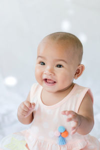 Cute baby girl sitting on bed