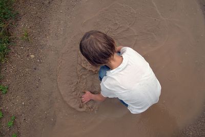 Directly above shot of girl playing in muddy water