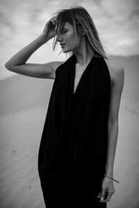 Woman standing at beach against sky