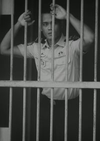 Guard standing behind prison cell