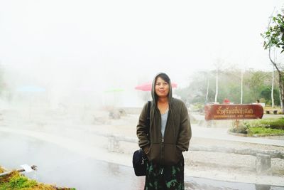 Portrait of smiling young woman standing outdoors